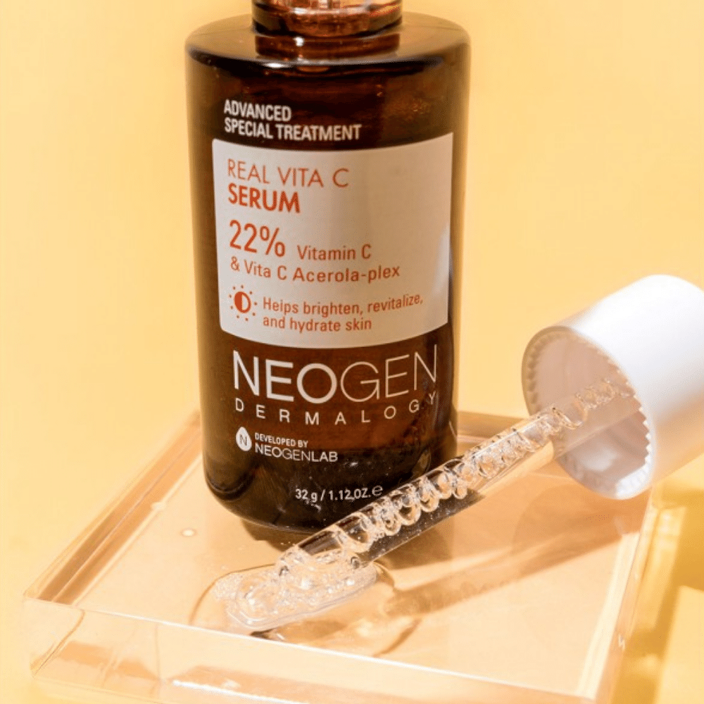 En flaska NEOGEN Dermalogy Real Vita C Serum 32g innehållande niacinamid bredvid en flaska vatten.